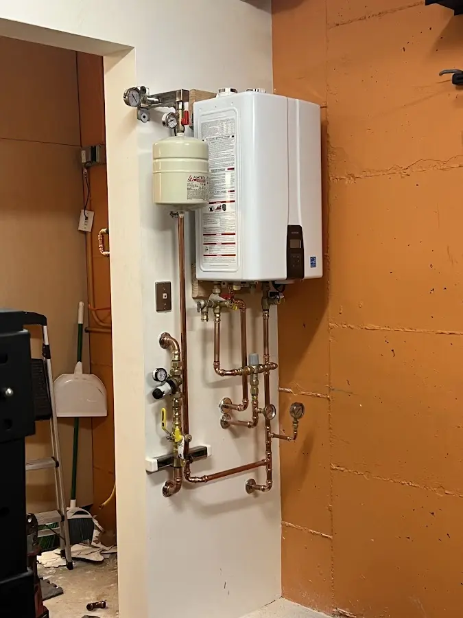 Plumbing technician inspecting water heater connections in Woods Cross
